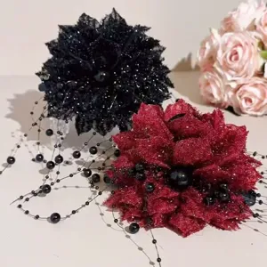 Gros plan détail de la pince à cheveux florale élégante avec des glands de perles noires.