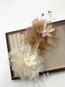 Detaillierte Nahaufnahme eleganter Blumen-Haarklammern mit Strasssteinen und Perlen.