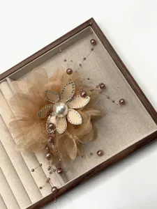 Nahaufnahme Detail der champagnerfarbenen Mesh Blumen Haarklammer mit Perlen und Strass.