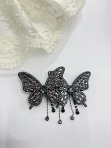 Detailed view of the sparkling crystal butterfly hair clip with elegant hanging bead tassels.
