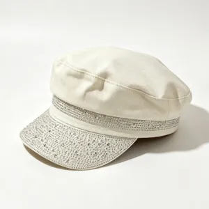 Vista dettagliata di un elegante berretto bianco con strass brillanti sulla visiera.