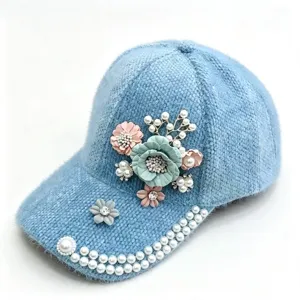 Detailansicht der hellblauen flauschigen Kappe mit Perlen und Blumen-Strasssteinen.