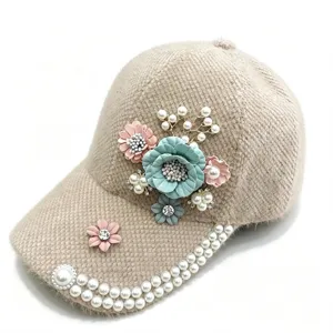 Nahaufnahme der plüschigen Blumen-Baseballkappe mit glitzernden Strasssteinen und Perlen.