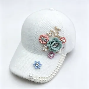Detaillierte Nahaufnahme der flauschigen weißen Damen Baseballkappe mit süßem Blumen Perlen Strass.