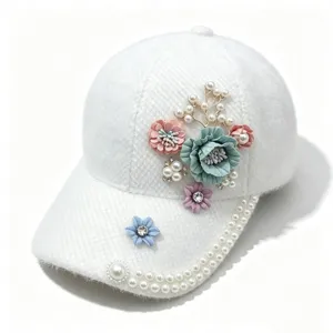 Detailansicht einer weißen Plüsch-Baseballkappe mit Stoffblumen, Perlen und Strasssteinen.