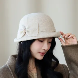 Close-up detail of women winter wool bucket hat with elegant bow and rhinestone decoration.