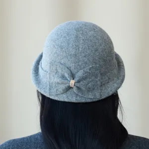 Detailed view of the grey wool blend cloche hat back, featuring an elegant bow and rhinestone ring.