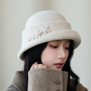Close-up detail of stylish beige woolen bucket hat with cute floral decoration for women.