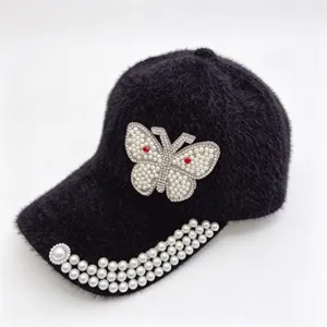 Gros plan de la casquette de baseball en peluche noire avec papillon et perles.