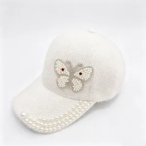 Vue détaillée de la casquette de baseball en polaire blanche avec papillon en strass et perles.