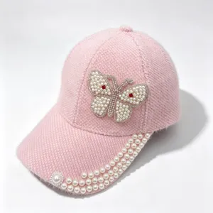 Casquette de baseball rose duveteuse avec papillon strass perles et bord perlé.