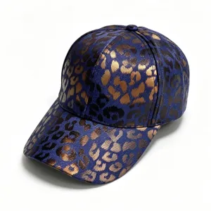 Close-up detail of the stylish blue denim baseball cap featuring a chic metallic gold leopard print pattern.