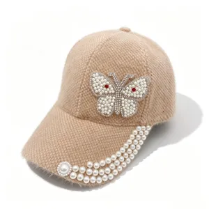 Vue de détail de la casquette beige duveteuse avec papillon en perles et strass.