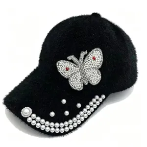 Détail casquette pelucheuse noire, ornement papillon perle strass, chapeau d'hiver chaud