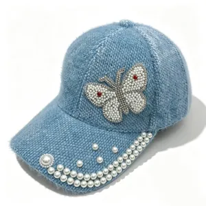Gros plan détaillé de la casquette pelucheuse d'hiver avec papillon perlé étincelant.