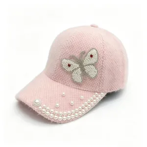 Vue détaillée de la casquette de baseball en fourrure synthétique rose et papillon perlé.