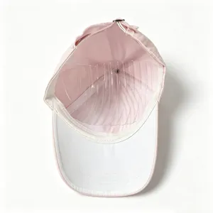 Detailed view of the pink baseball cap interior with clear shaper insert and white brim.
