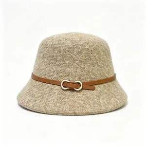 Detailopname van de wollen bucket hat met bruine lederen riem en metalen gesp.