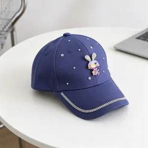 Gedetailleerd uitzicht op de blauwe kinderpet met strass konijnenhanger en fonkelende randafwerking.