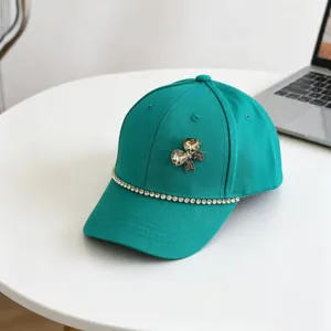 Detail view of children baseball cap with rhinestone bow and sparkling chain decoration.