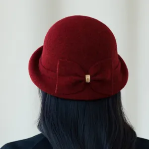 Detail of the french vintage wool blend cloche hat with cute bow decoration in dark red.