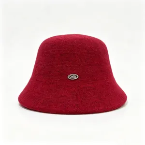 Detalle de sombrero de cubo de mezcla de lana roja, accesorio de invierno con insignia