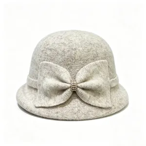 Close-up of the elegant wool-blend cloche hat featuring a large knit bow and sparkling rhinestone.