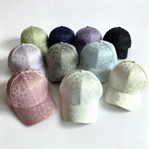 Close-up view of stylish rhinestone floral baseball caps in various colors, fine fabric detail.