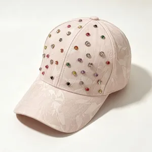 Gedetailleerd overzicht van de roze strass honkbalpet met een subtiel bloemenreliëf.