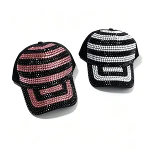 Detail van rhinestone honkbalpet met sprankelende gestreepte patronen op zwarte stof.