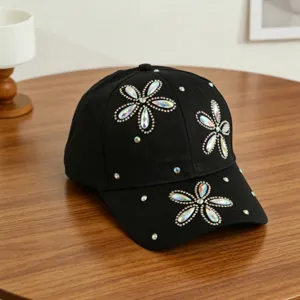 Gedetailleerd overzicht van zwarte honkbalpet versierd met sprankelende kleurrijke strass bloemen.