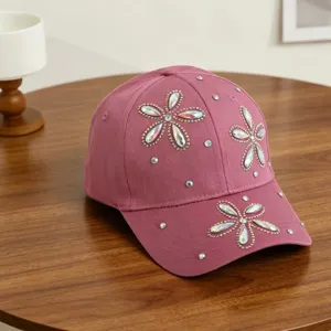 Detailopname van de roze honkbalpet voor kinderen met fonkelende strass-steentjes bloemmotieven.
