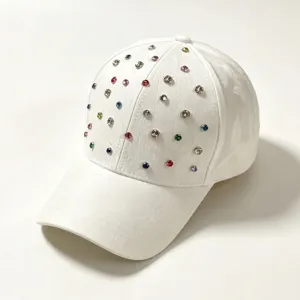 Close-up detail van sprankelende veelkleurige strass-steentjes op witte honkbalpet stof.