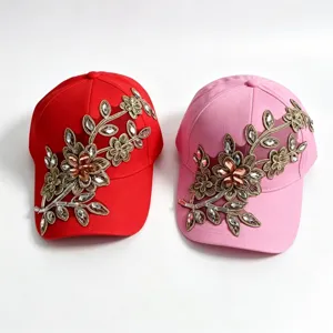 Vista dettagliata del cappellino con strass e ricamo floreale in filato dorato molto trendy.