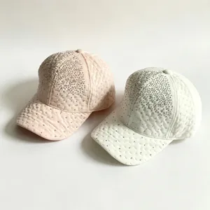 Vue rapprochée des casquettes matelassées de strass en rose et blanc mettant en valeur les cristaux.