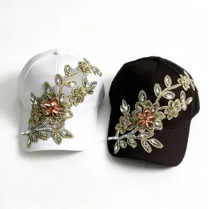 Vista dettagliata di eleganti berretti da baseball con strass e ricami in oro bianco e nero.