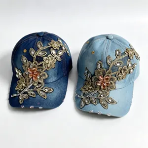 Primo piano del berretto in denim ricamato con strass e filo d'oro, bellissimo motivo floreale.