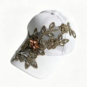 Elegante cappello da baseball bianco con ricamo floreale dorato e strass cristalli luminosi.
