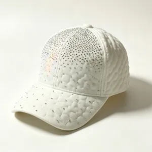 Gros plan sur la casquette blanche matelassée avec des strass étincelants et détail holographique.