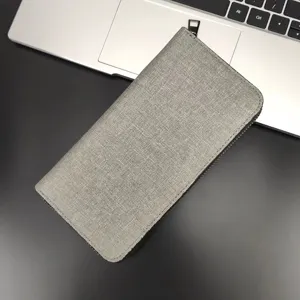 Primo piano del portafoglio lungo in tela grigia con zip, che mostra la texture e gli spazi.