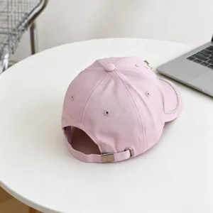 Roze honkbalpet detailweergave met glinsterende strass-steentjes en metalen verstelriem.