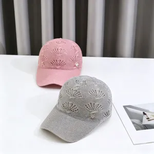 Hollow knitted baseball cap detail showcasing delicate crown pattern and rhinestone.