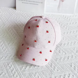 Close-up of pink waffle texture baseball cap decorated with rhinestones and cute red cherries.