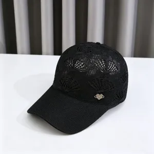 Detailed view of the black knit hollow crown flower baseball cap with rhinestone heart charm.