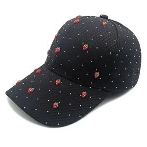 Close-up detail of black waffle baseball cap with cute red strawberries and starry studs.