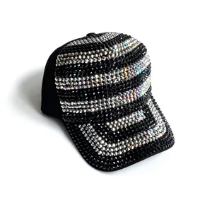 Close-up detail van een zwarte strass honkbalpet met sprankelende kristallen strepen.