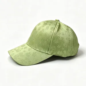 Green satin baseball cap with clover pattern and delicate rhinestone details. Detail view.