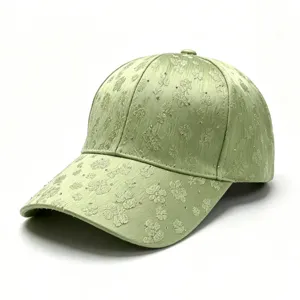 Detailed view of light green women's baseball cap with floral embroidery and rhinestones.