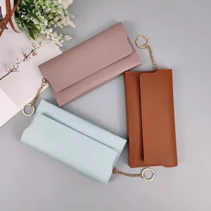 Detail view of women's long PU leather wallet with snap closure and chic metal chain.