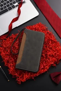 Vista dettagliata del portafoglio lungo da uomo con laccetto su carta decorativa rossa.